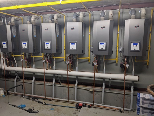 Bank of commercial tankless water heaters installed by Hydroflame.