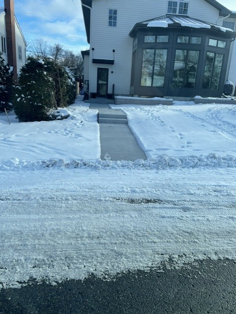 Snow-covered residential driveway with hydronic snow melt beneath.