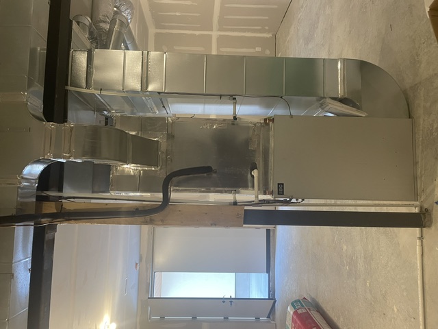 Hydronic air handler installed in a ceiling cavity.