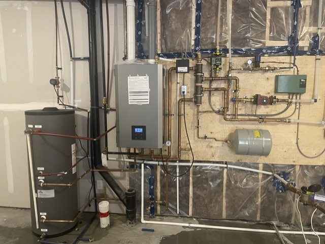 Residential multi-function boiler system with domestic hot water tank and hydronic piping.
