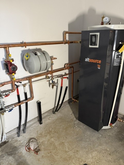 Indoor air-to-water heat pump setup with hydronic piping.