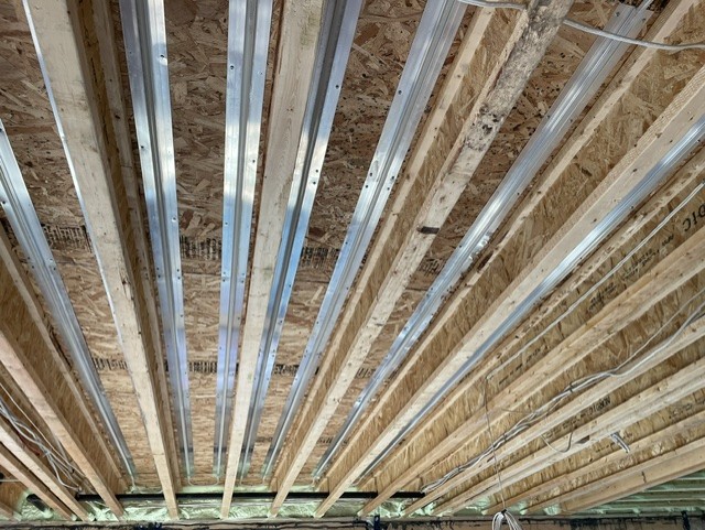 Radiant floor heating tubing installed in a joist cavity.