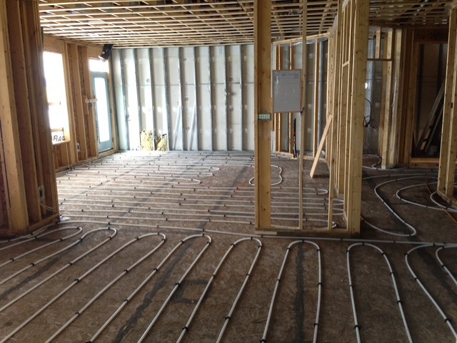 Radiant floor heating tubing laid out over a concrete pour area.